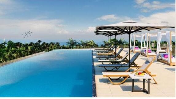 Lounge area with sunbeds and bar on rooftop